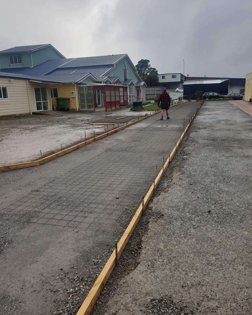 Steel mesh and timber boxing laid out for a concrete accessway between houses