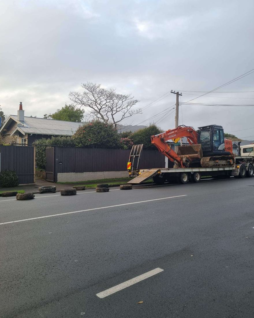 Orange excavator on a transporter trailer ready to move between sites