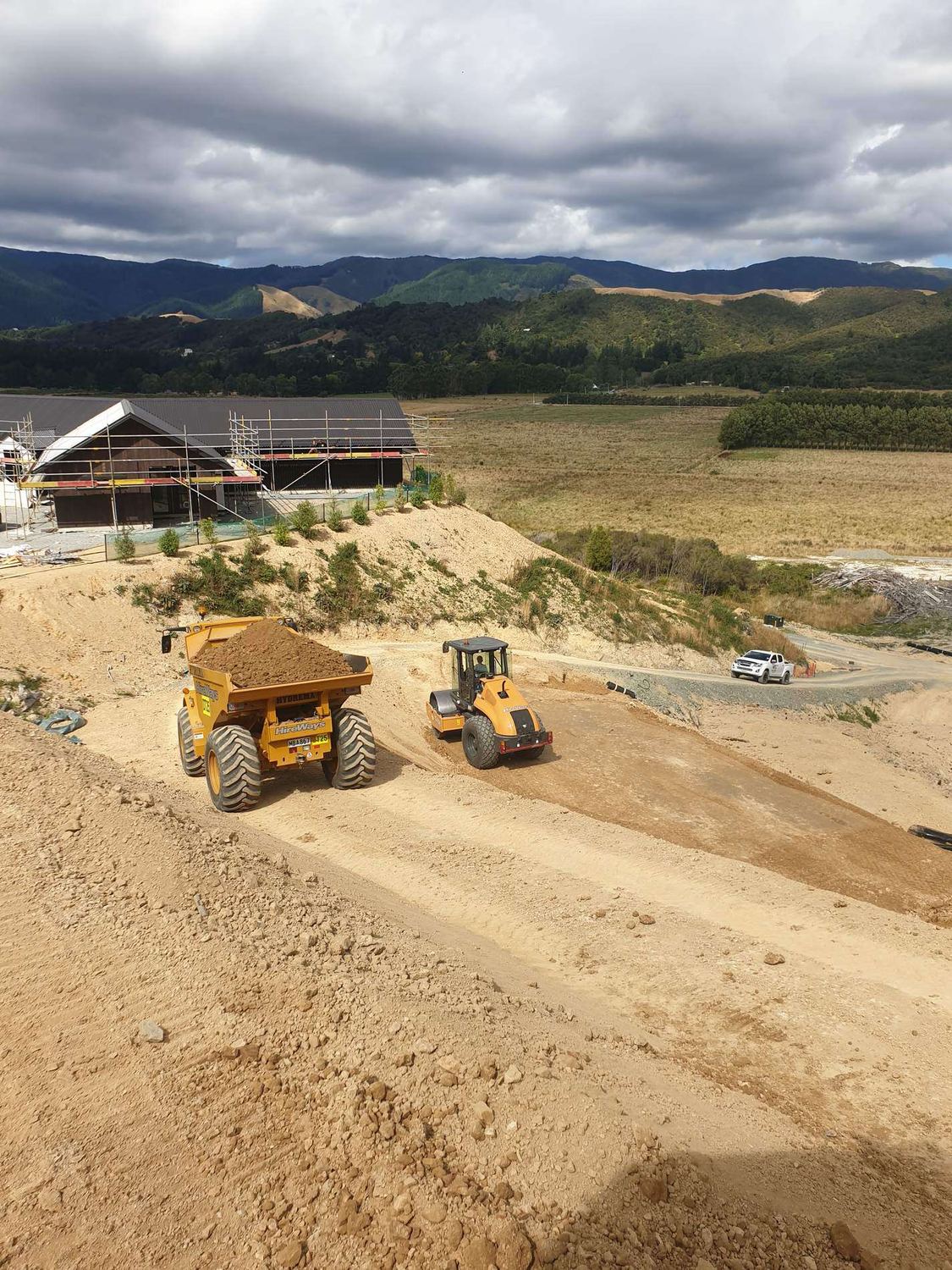 Dump truck being loaded by a wheel loader on a large earthworks cut