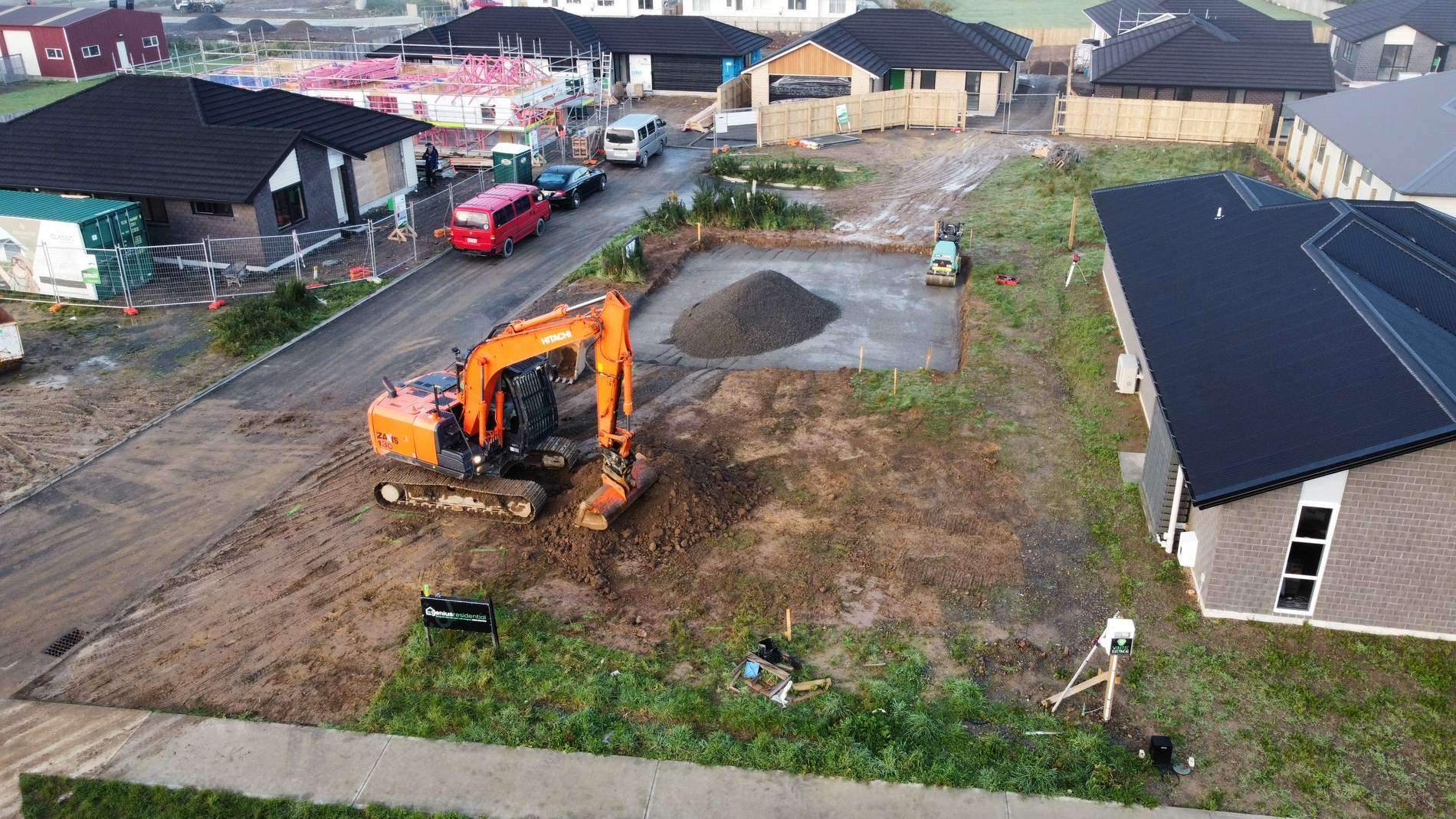 Aerial view of an excavator preparing a residential section between new houses