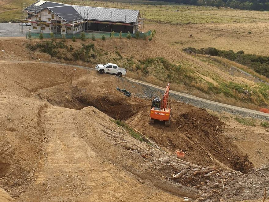 Excavator working in a deep bulk excavation on a rural hillside